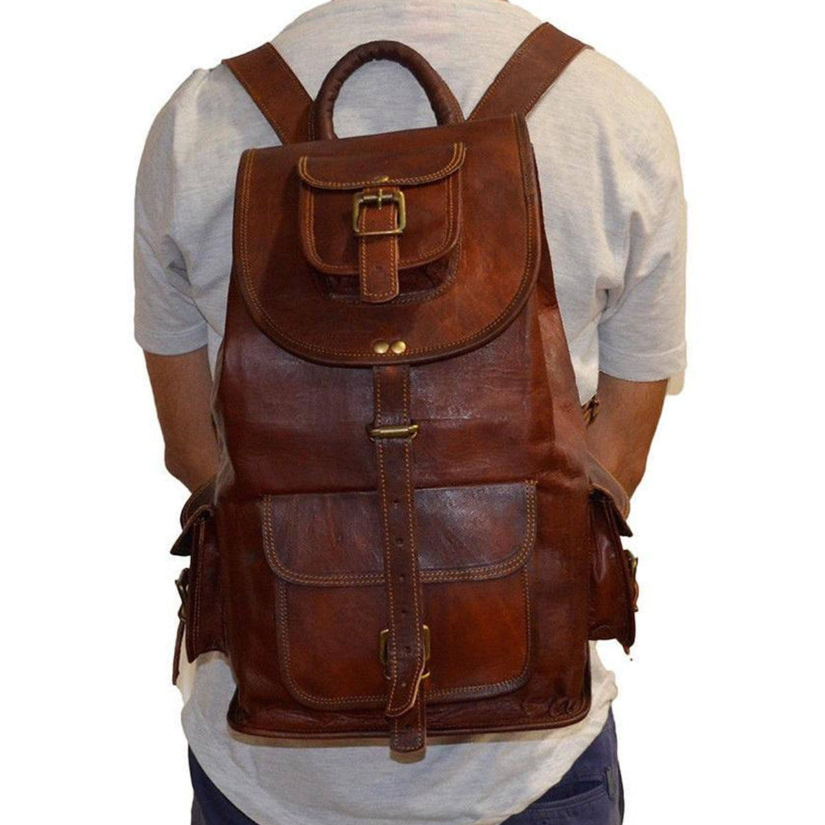 Brown leather hiking backpack worn on back, front pocket flap and shoulder straps