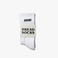 White crew socks with black Bread Socks logo on ribbed knit cuff