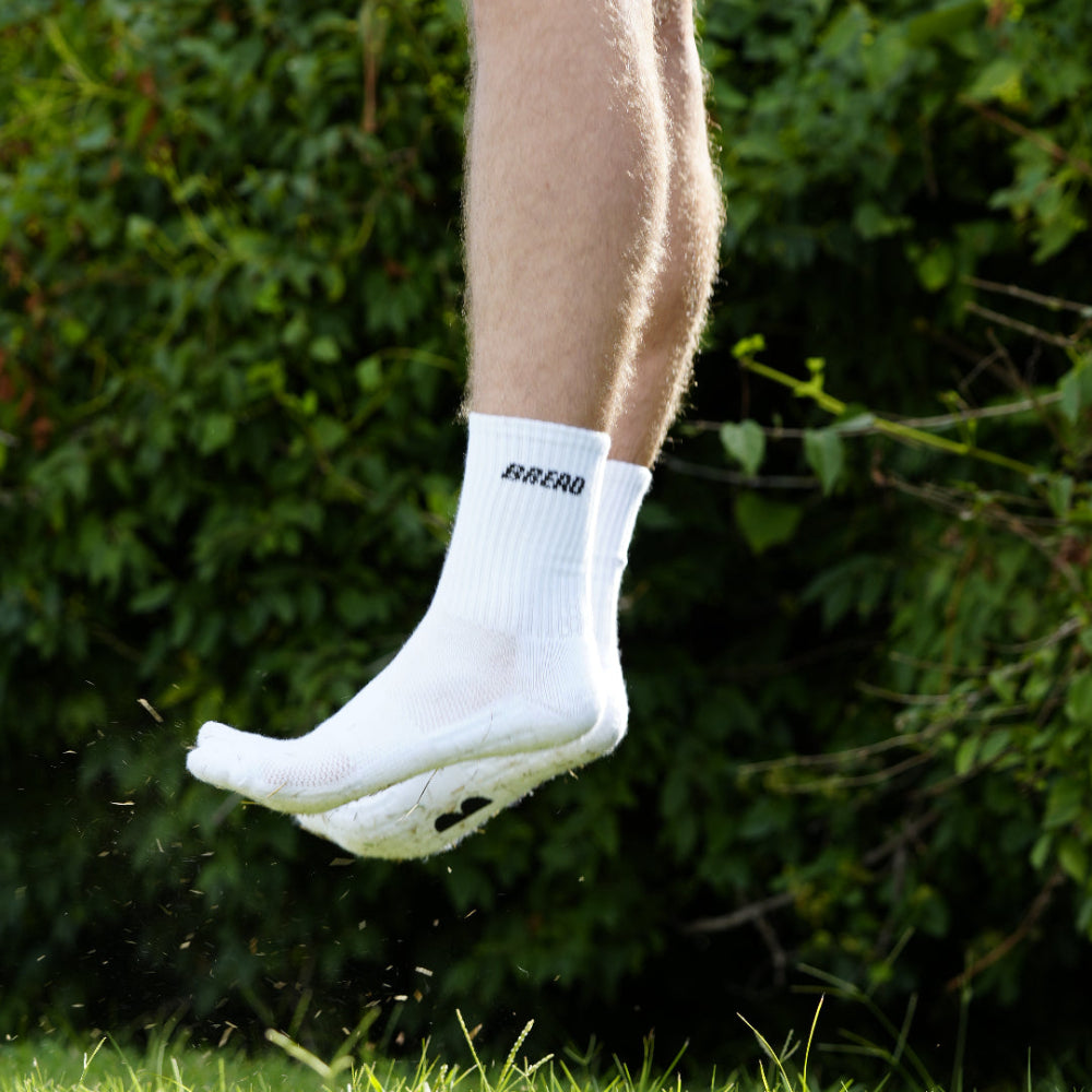White crew socks with black Bread logo text, ribbed knit and snug cuff