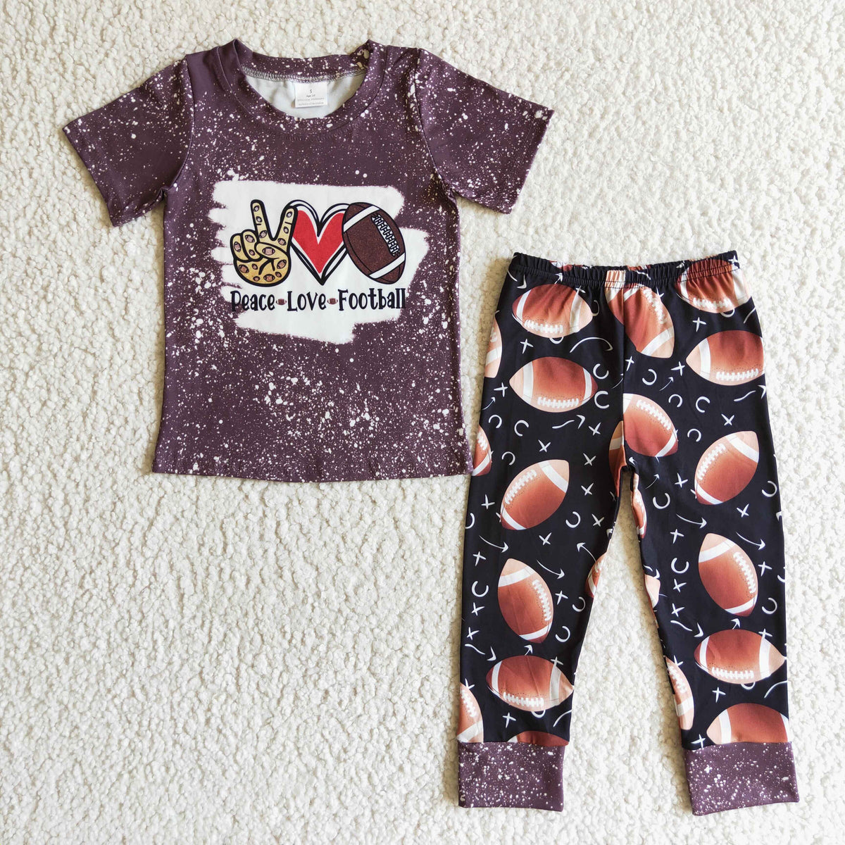Kids football outfit set with maroon graphic T-shirt and black football-pattern pants, cuffed hem