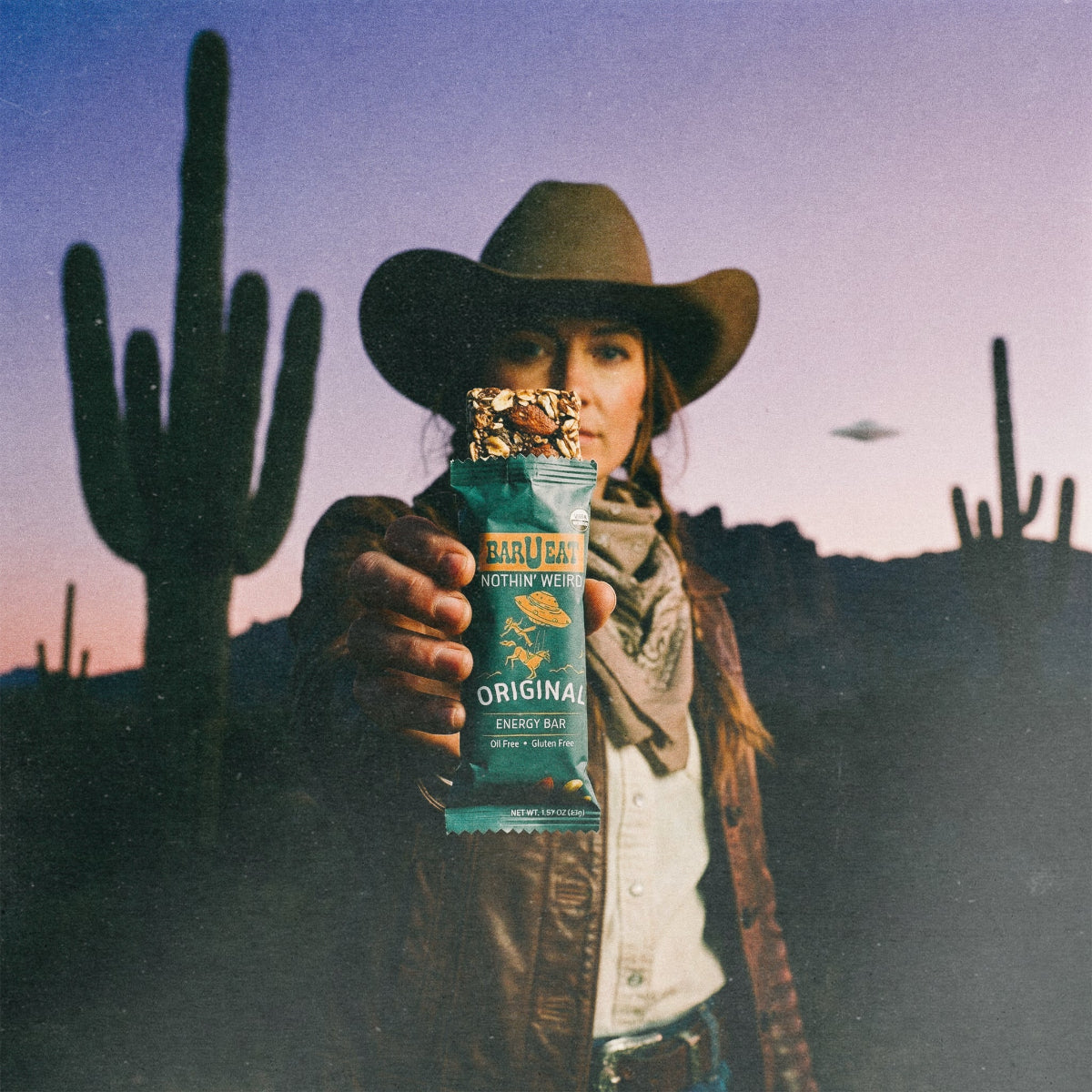 Original energy bar in wrapper held by cowboy hat person