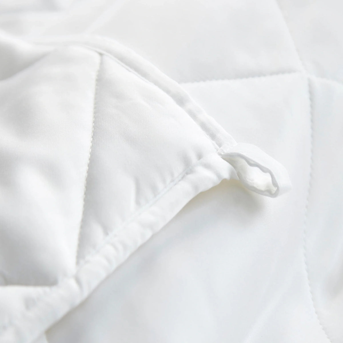 White duvet comforter corner with stitched edge and quilted baffle panels