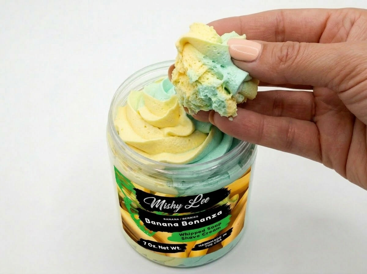 Hand scooping whipped soap and shave cream with yellow and mint swirled texture