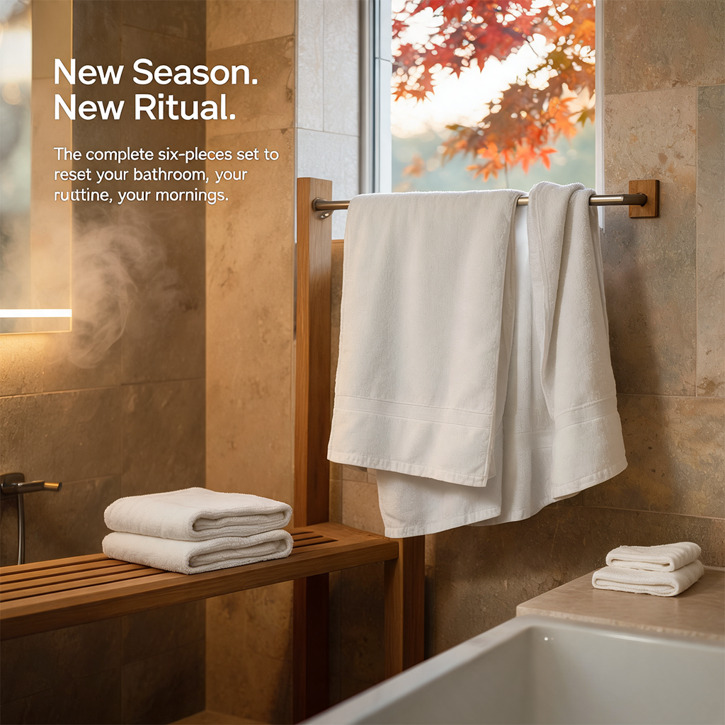 White bath towel set with stacked towels and one rolled towel on a counter
