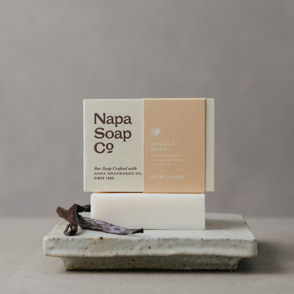 Vanilla bar soap with visible bar on stone tray, with white and kraft-brown boxes