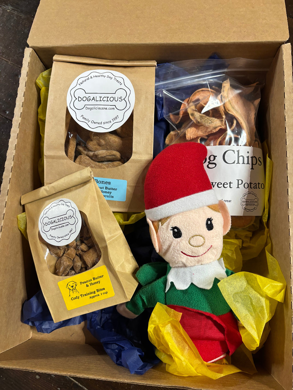 Bark-cuterie Pack Plus gift box with dog treats, sweet potato chips, and a plush elf toy