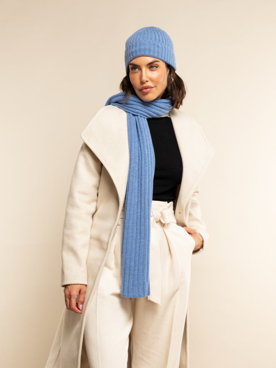 Light blue ribbed beanie worn by woman with matching scarf