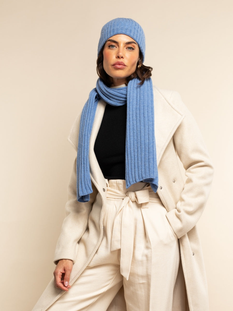 Light blue ribbed beanie and matching scarf worn with cream coat
