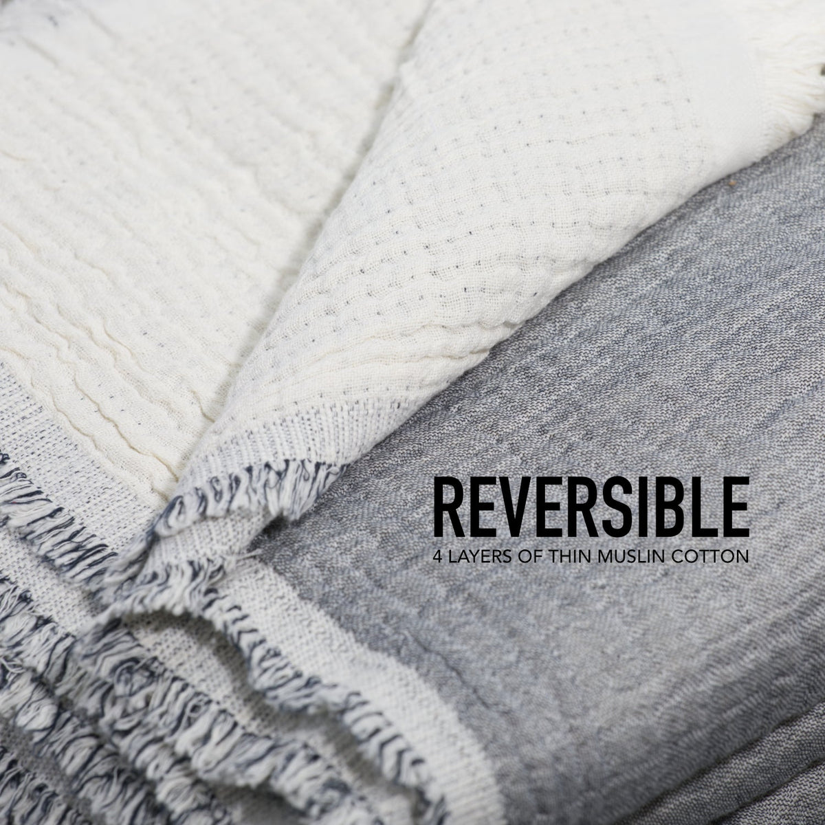 Close-up of reversible muslin coverlet with grey side and ivory side, fringed edge