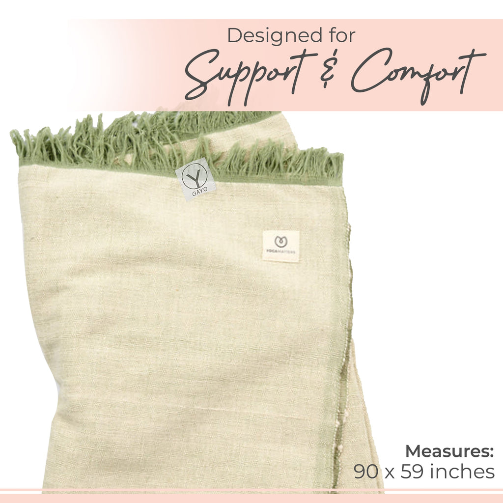 Light green organic cotton yoga blanket with logo patch and finished fringed edge.