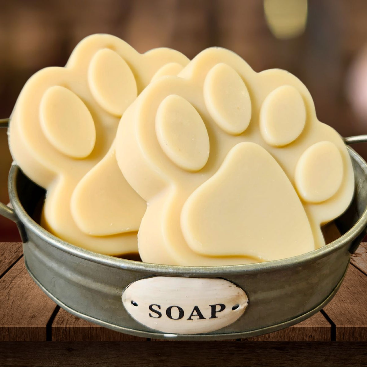 Paw-shaped goat milk soap bars in metal bowl, light cream color