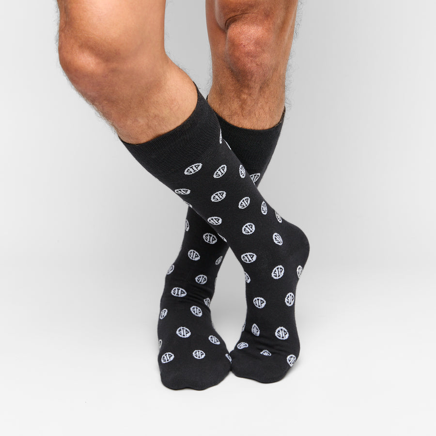Black crew socks with white circular logos, ribbed ankle cuffs
