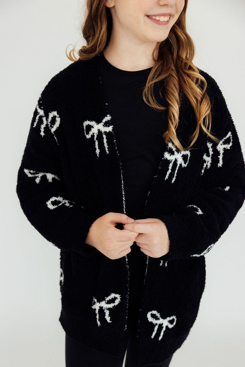 Black bow-pattern cardigan, long sleeves, button-front close-up