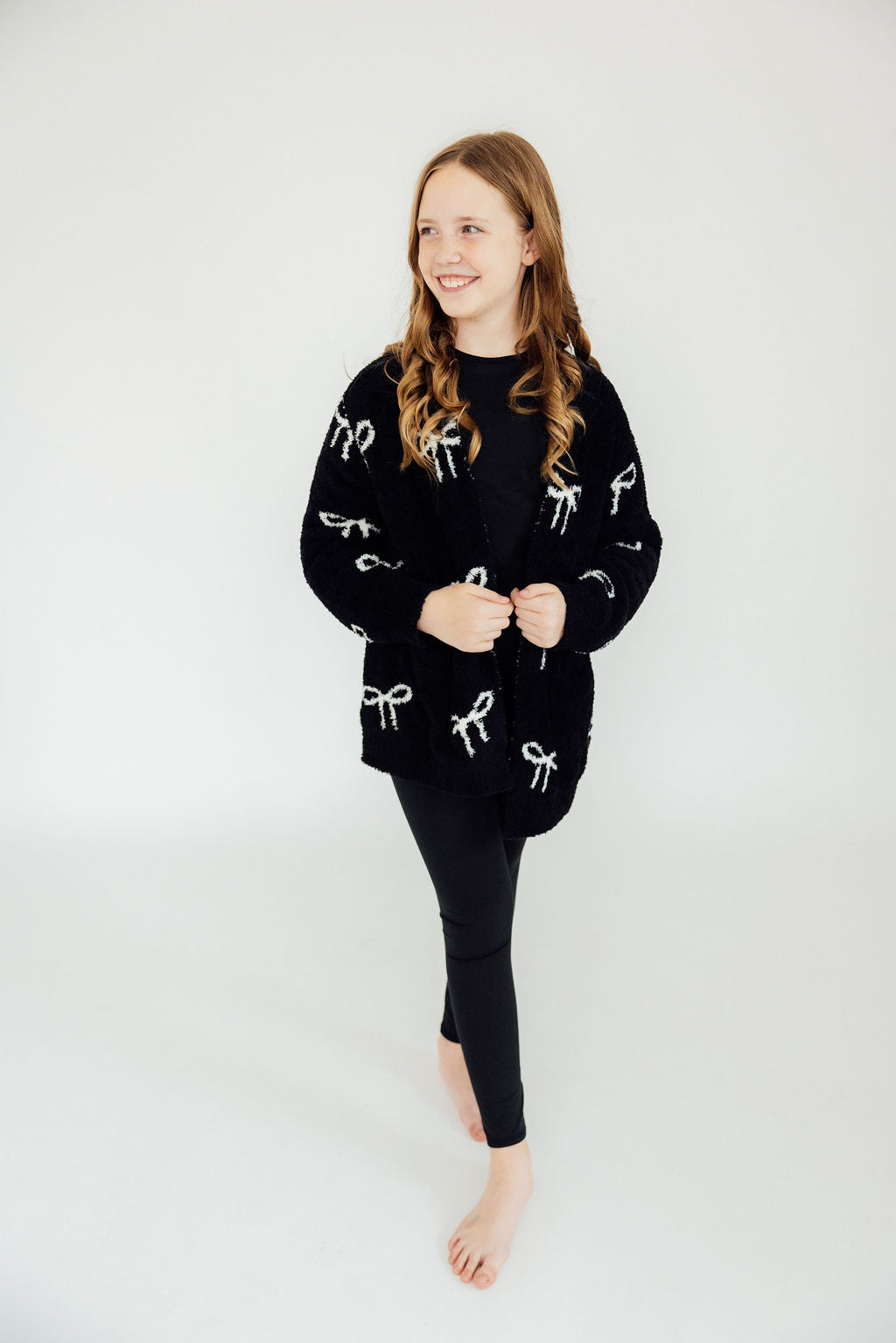 Black bow-pattern cardigan with long sleeves and button-front, crew neck