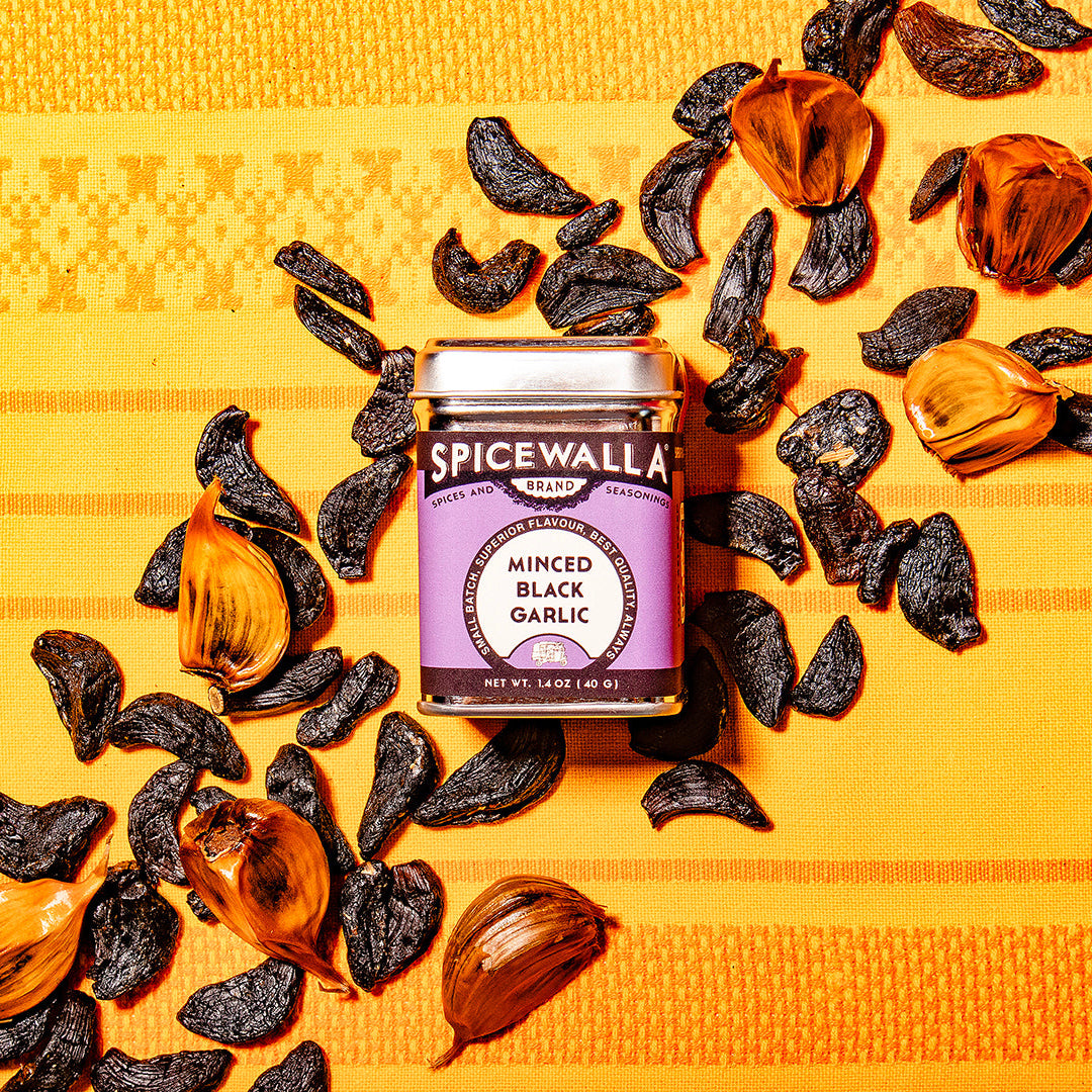 Spicewala minced black garlic seasoning jar with scattered black garlic pieces