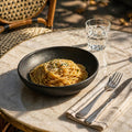 Black matte stoneware pasta bowl holding a serving of spaghetti and sauce