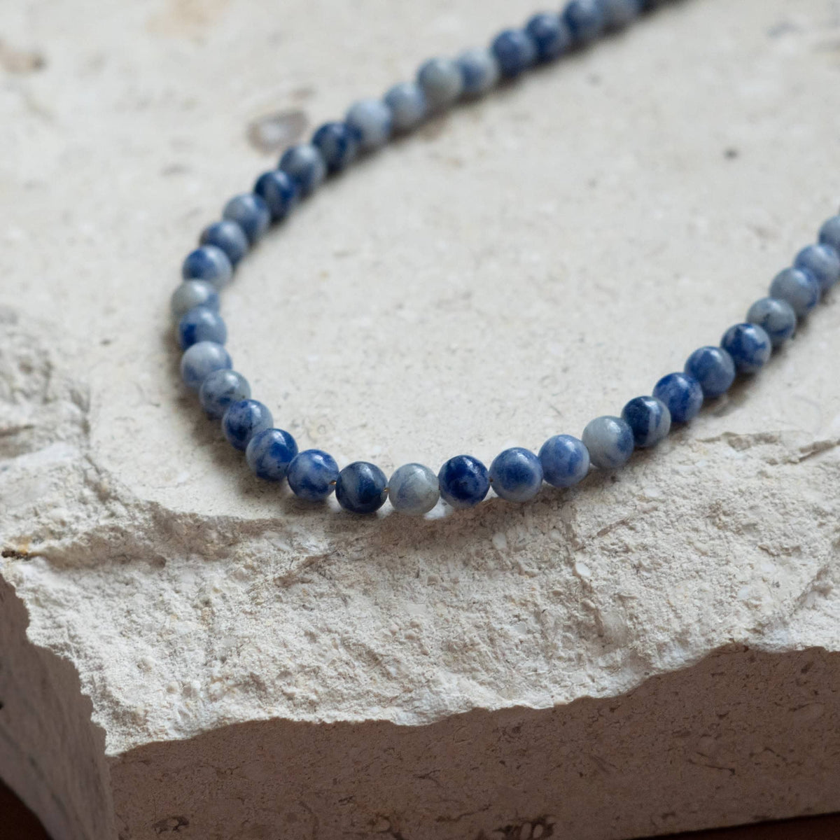 Blue beaded necklace close-up of navy and light-blue round beads
