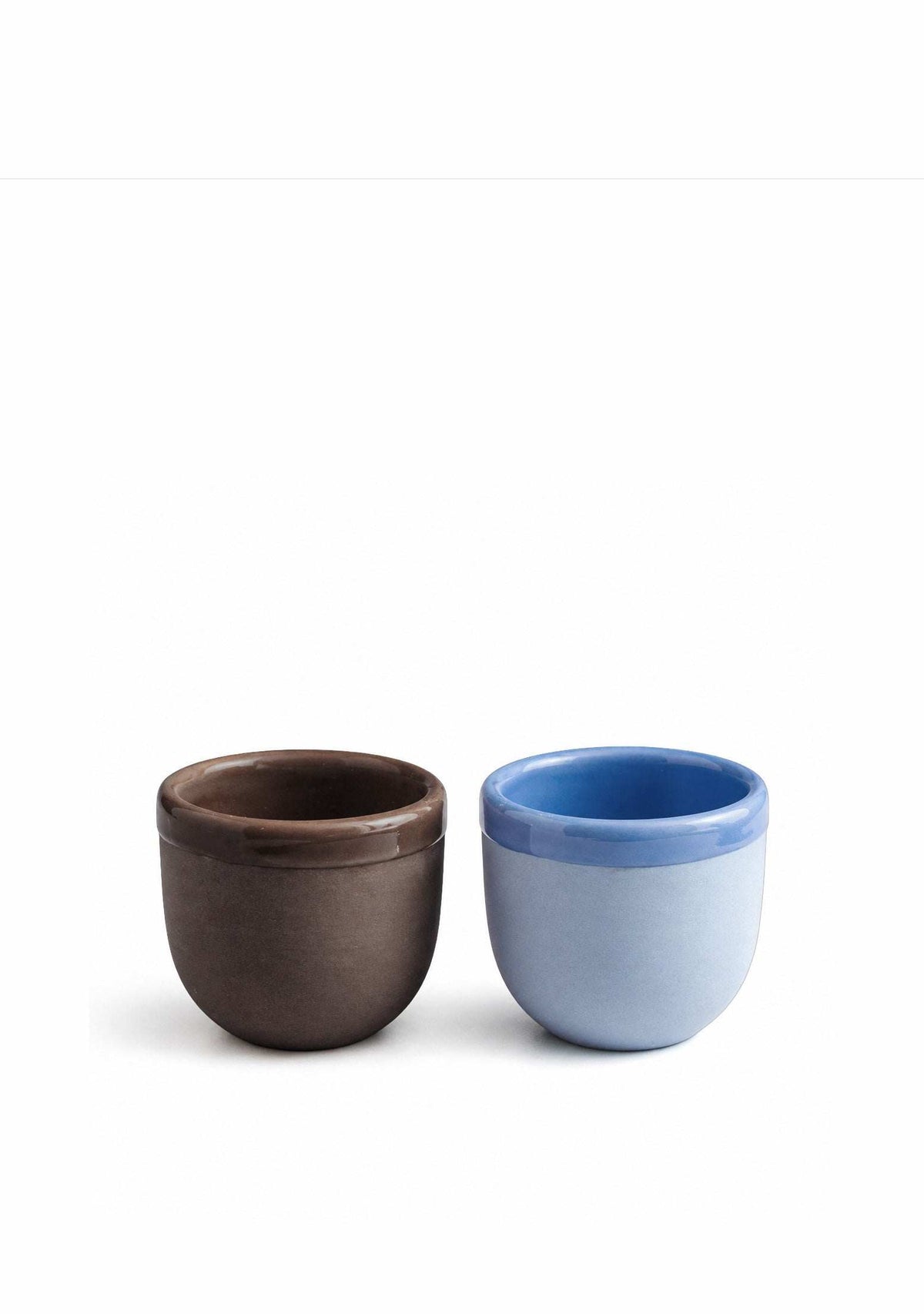 Pair of ceramic espresso cups in brown and blue, rounded form with open top.