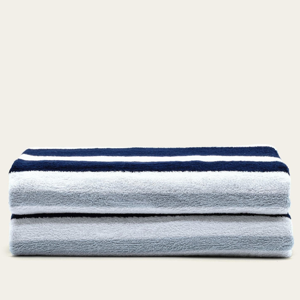 Cotton beach towel set in light gray with navy and white horizontal stripes, folded stack
