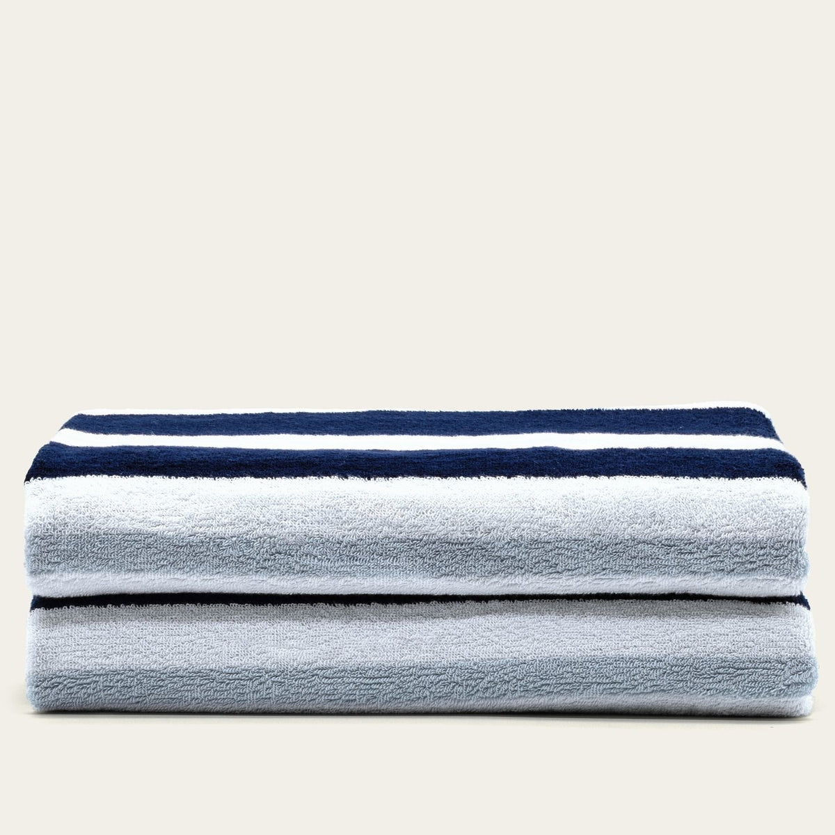 Cotton beach towel set in light gray with navy and white horizontal stripes, folded stack