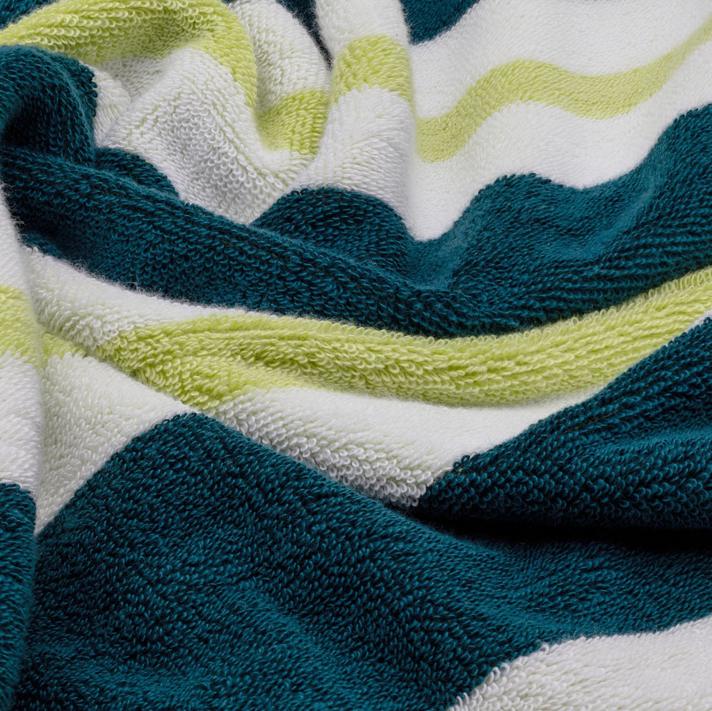 Cotton beach towel fabric close-up with teal, white, and light-green wavy stripes