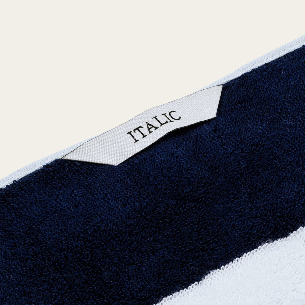 Cotton beach towel corner with small woven label reading "ITALIC"