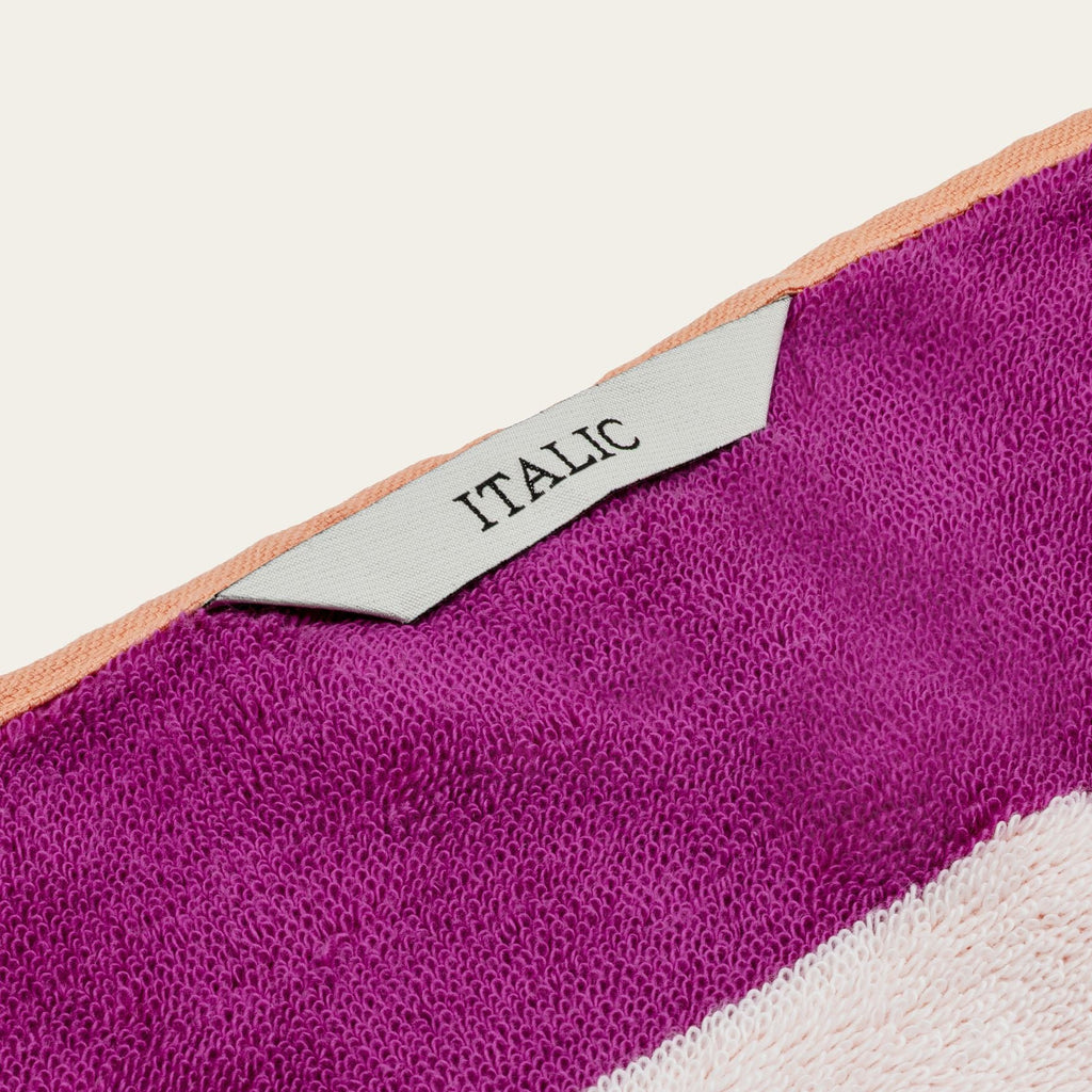 Cotton beach towel corner with woven “ITALIC” tag and “CABANA CLUB” text