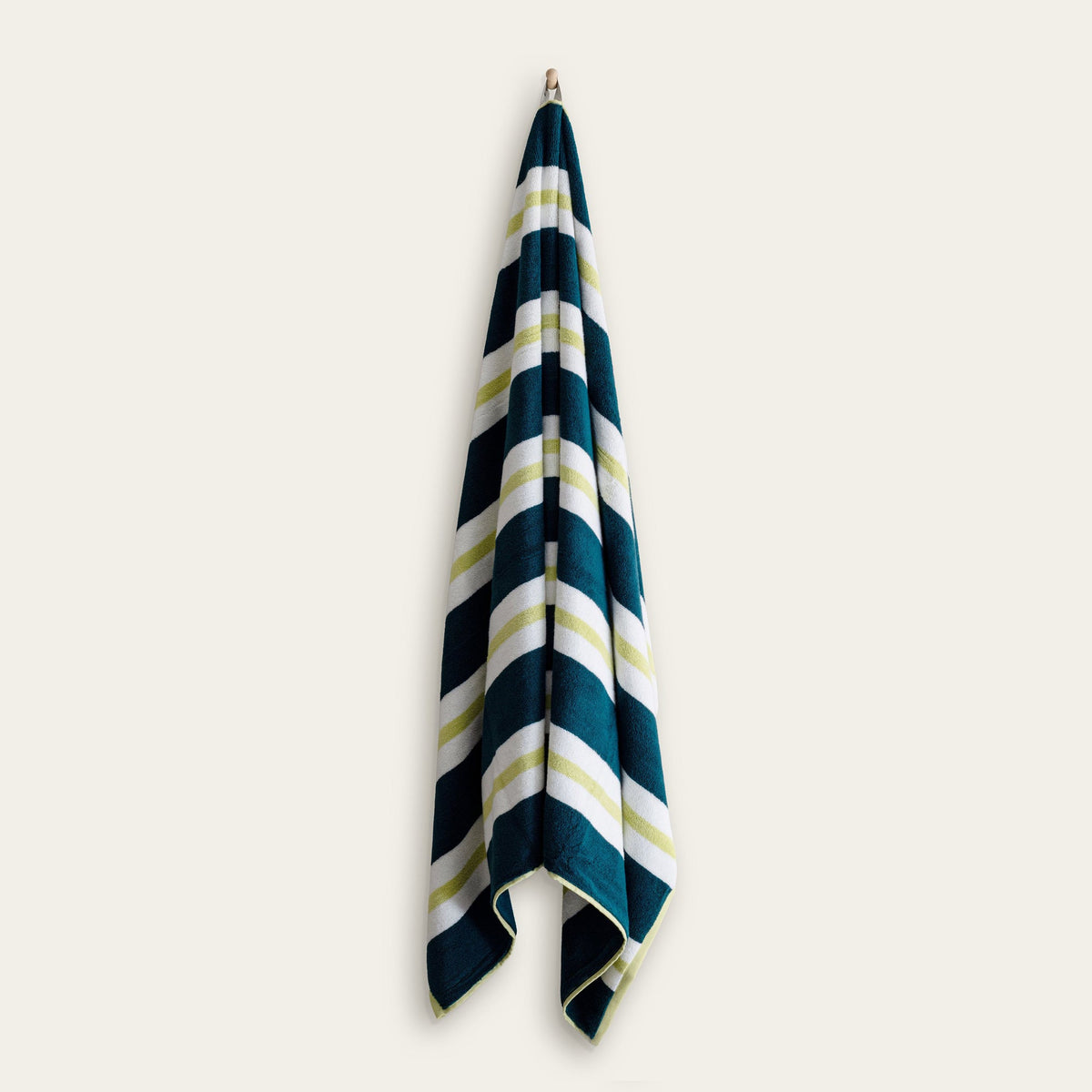 Navy and teal striped cotton beach towel hanging, with cream and lime stripes