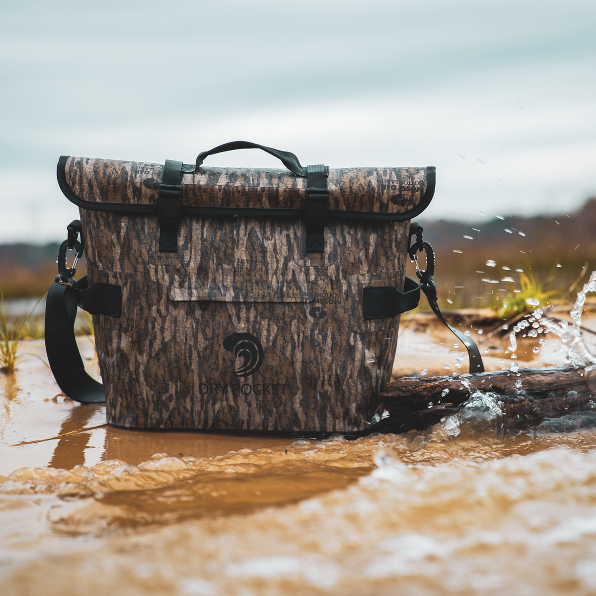 Waterproof floating cooler bag in Bottomland camo with water splash around the base