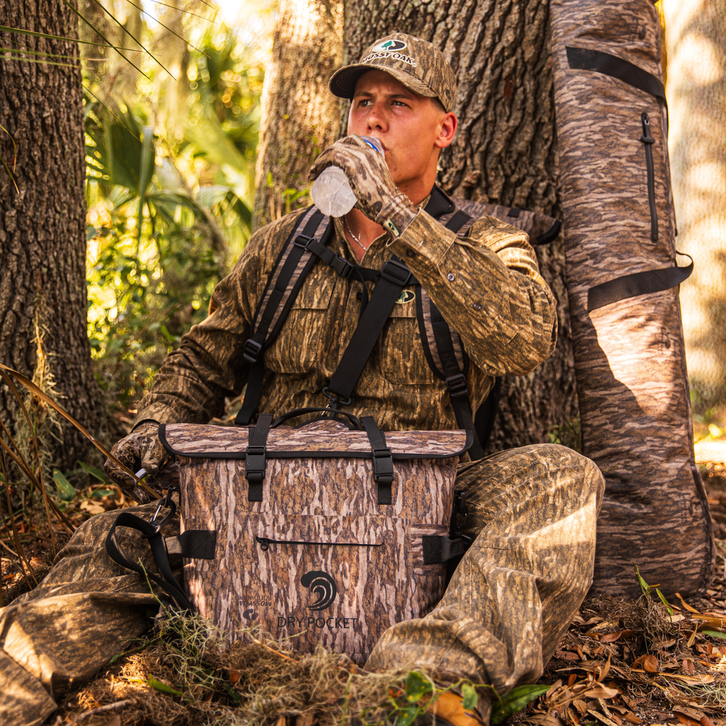 Waterproof floating cooler bag in Bottomland camo with front pocket and webbing straps