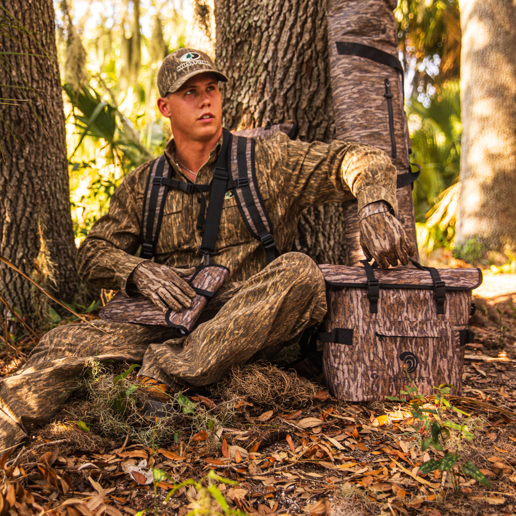 Waterproof floating cooler bag in bottomland camo with front straps and roll-top lid