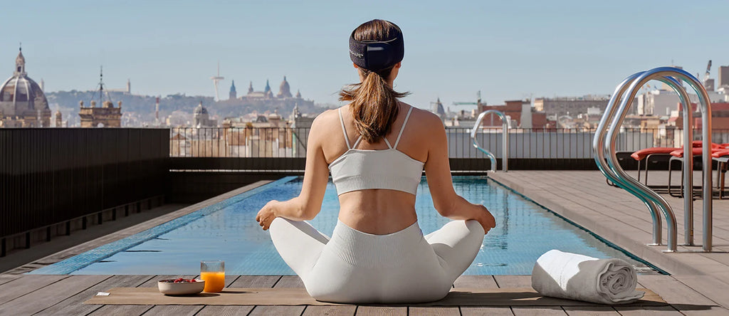 Black NeuroWrap headband worn by woman in sports bra during stretching
