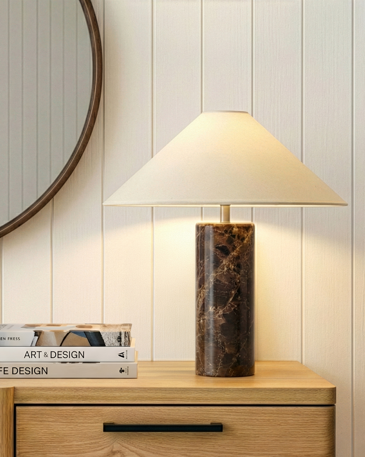 Table lamp with cream fabric shade and light beige travertine cylindrical base.