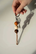 Handmade ceramic keychain with dark brown, cream, and orange beads plus tassel keyring