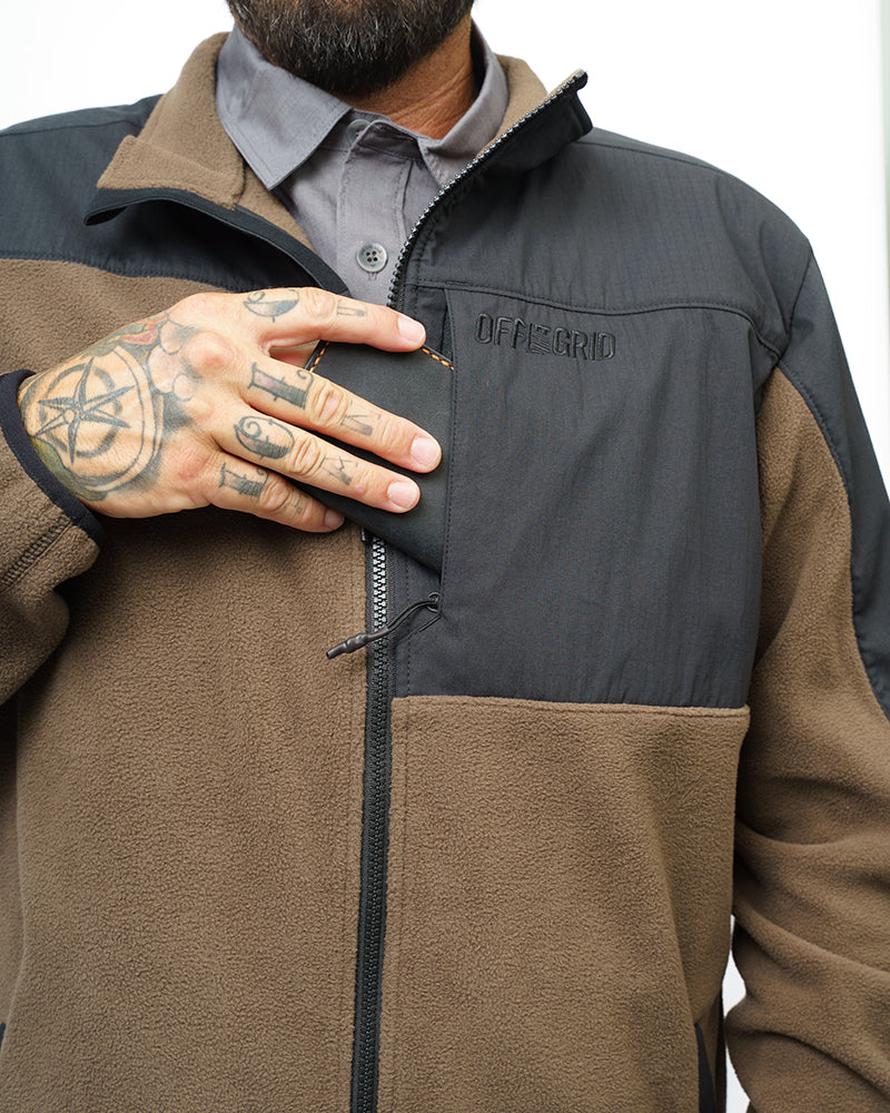 Close-up of two-tone fleece zip-up jacket with front zipper and chest logo patch.