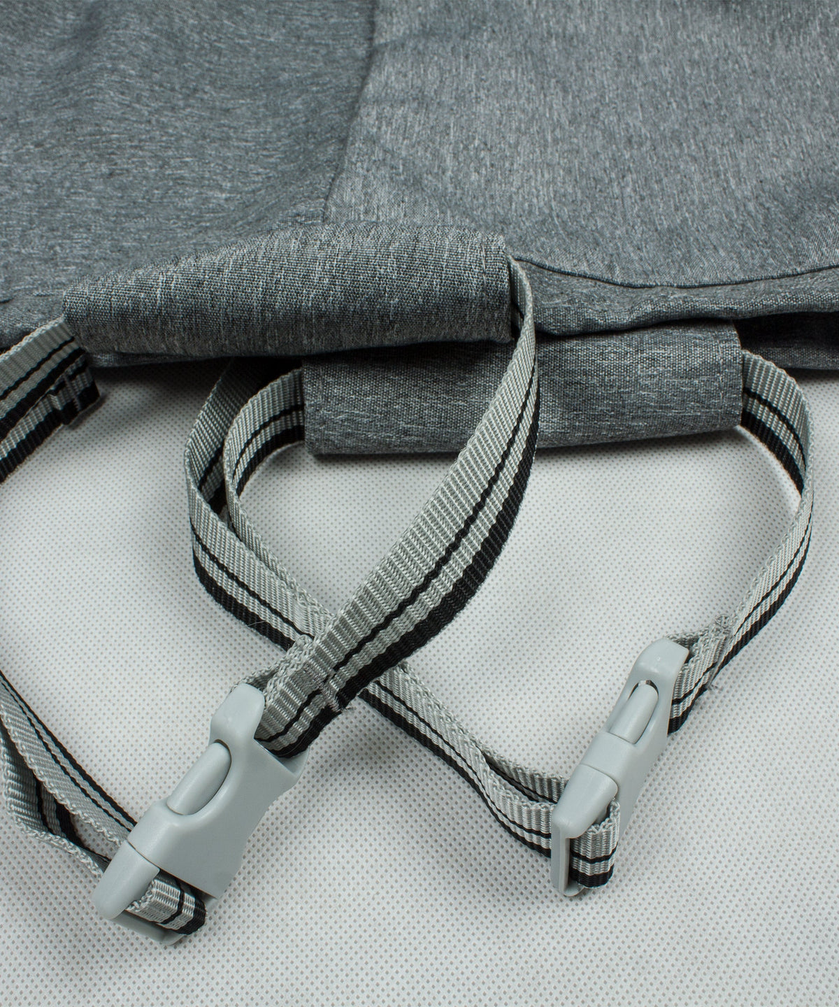 Gray loveseat cover close-up of fastening straps with gray plastic clips