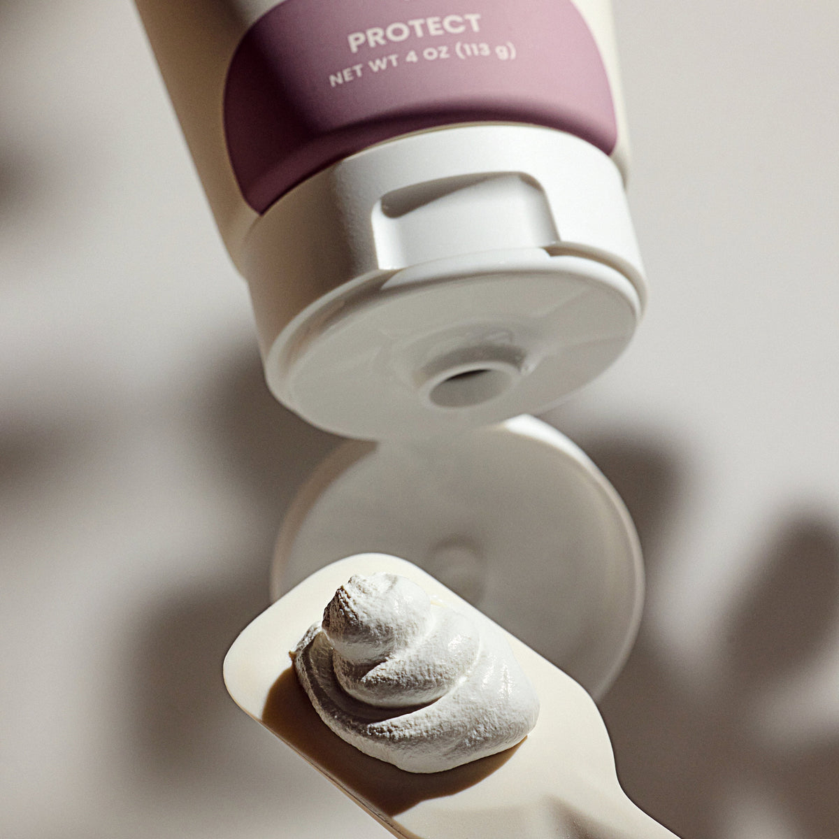 Diaper rash cream dispenser with white foam on an applicator