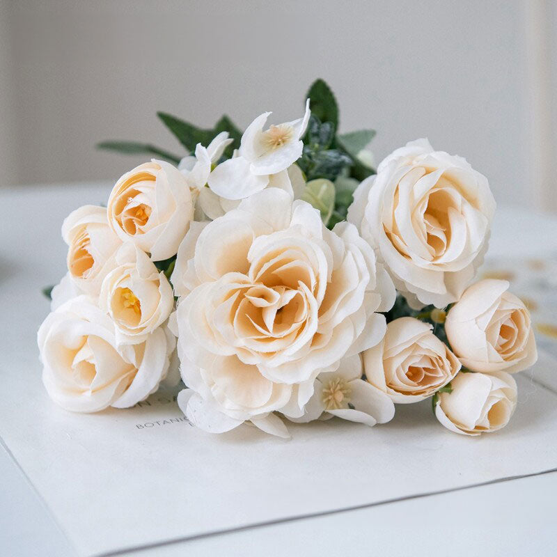 Cream and white silk rose bouquet with small white flowers and green leaves