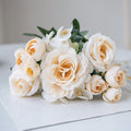Cream and white silk rose bouquet with small white flowers and green leaves