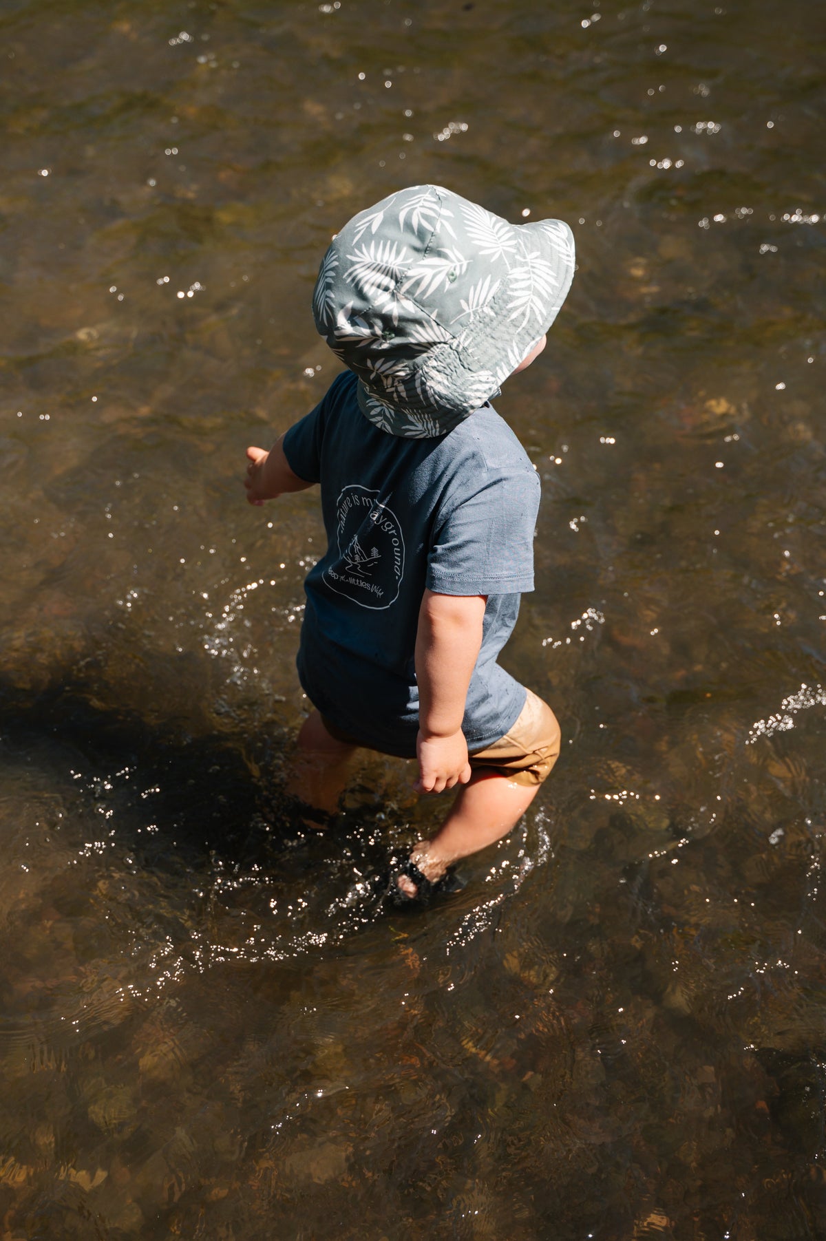 Kids blue bamboo T-shirt with circular nature graphic worn during water play