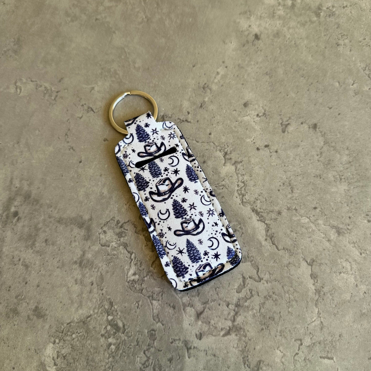 White chapstick holder keychain with navy cowboy doodle print