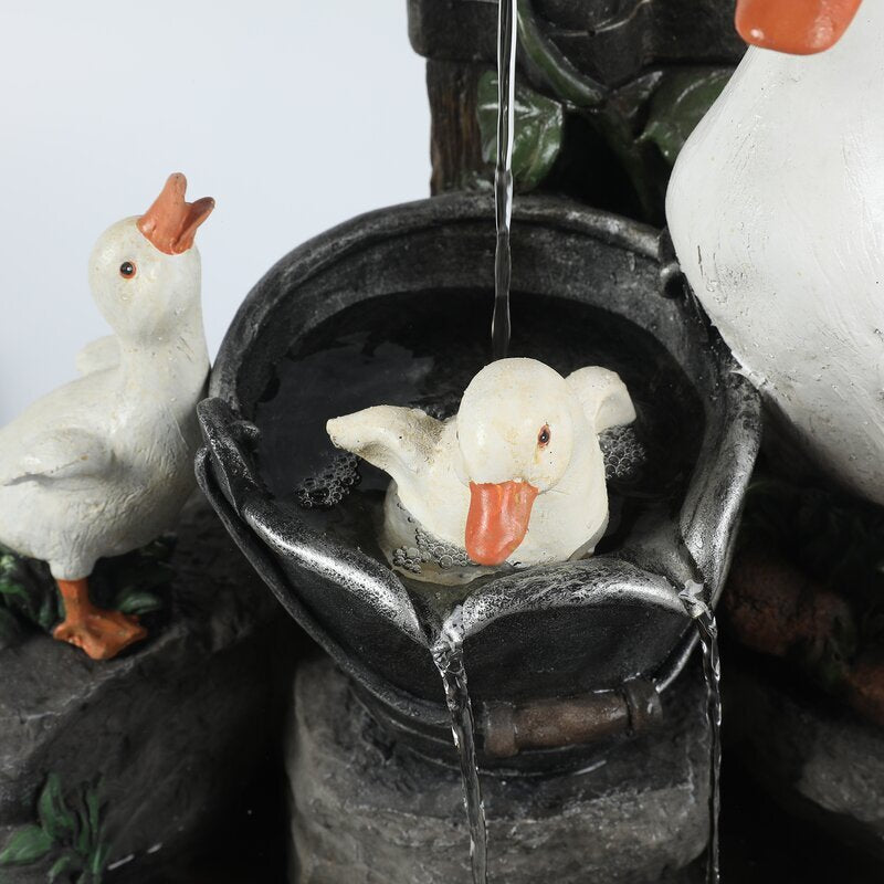 White duck resin fountain nozzle with water pouring into circular basin