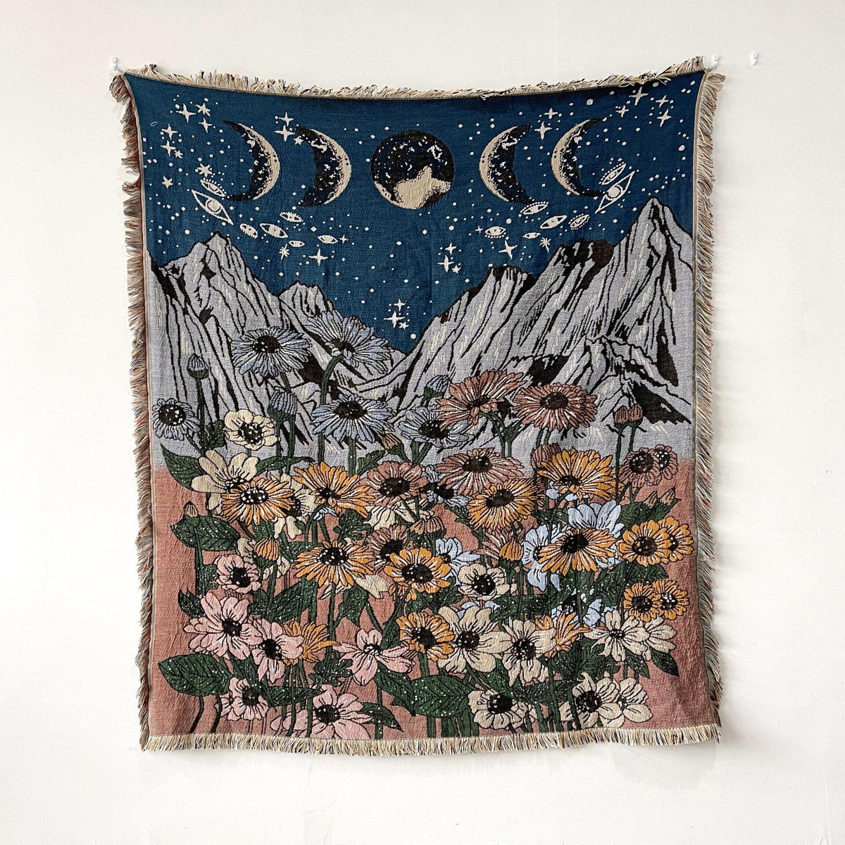 Night sky floral throw blanket with mountains, stars, moons, and fringed border
