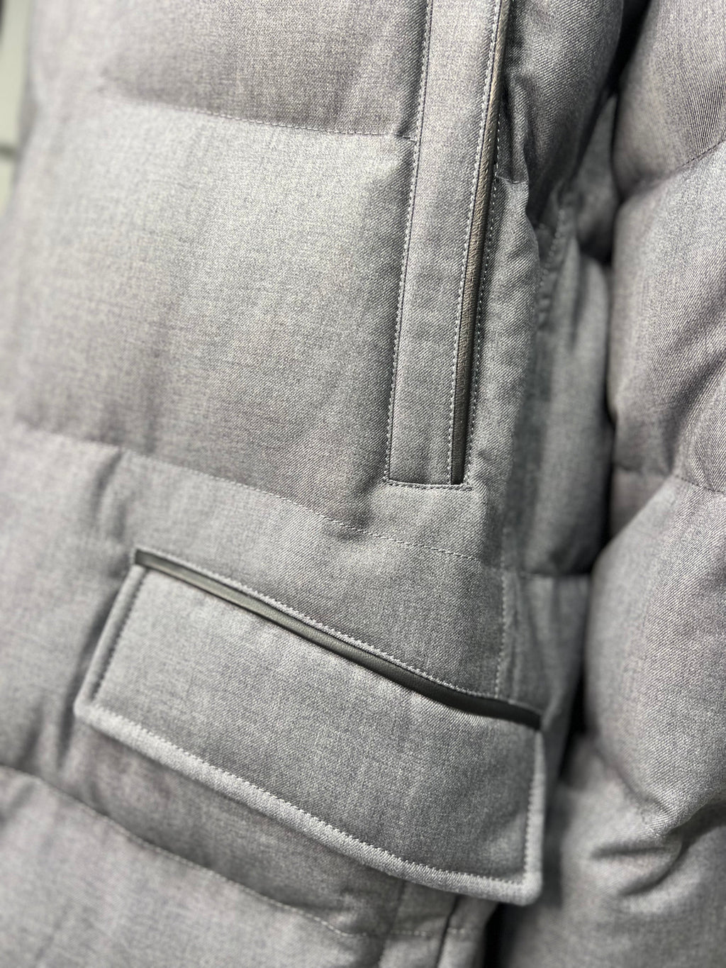 Grey padded coat front pocket with flap and vertical stitch panel