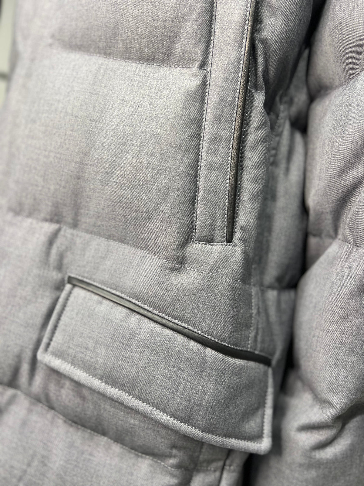 Grey padded coat front pocket with flap and vertical stitch panel