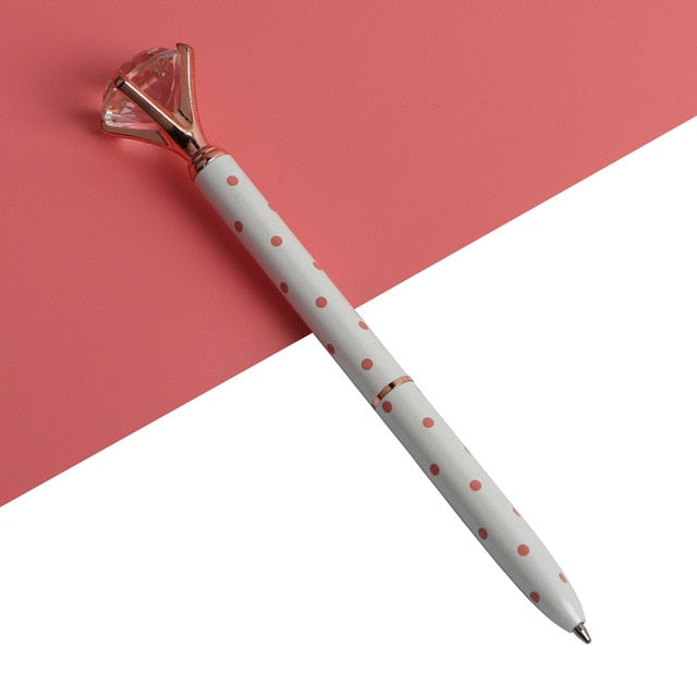 White ballpoint pen with red polka dots and faceted gold gem top, metal tip