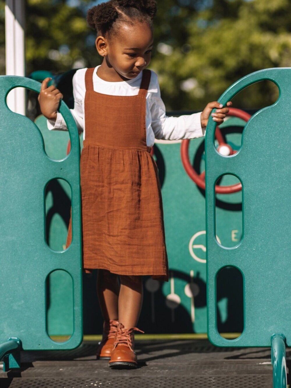 Brown lace-up toddler shoes, side view while child stands on steps