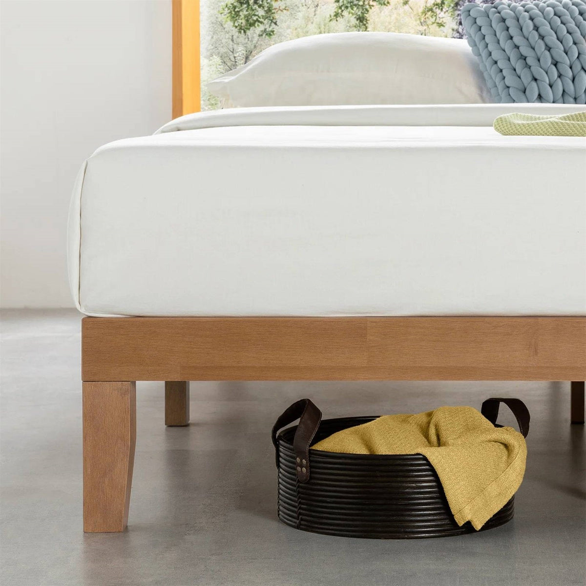 Close view of the bed frame's wooden side rail and tapered leg