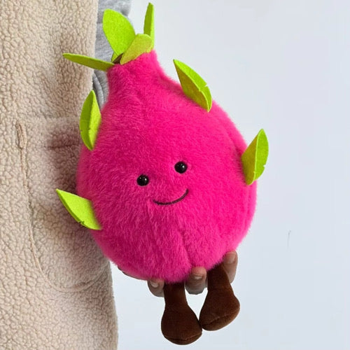 Pink dragon fruit plush toy close-up, green leaves, button eyes and smile