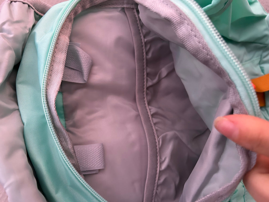 Light blue backpack interior lining and pocket area near zipper opening